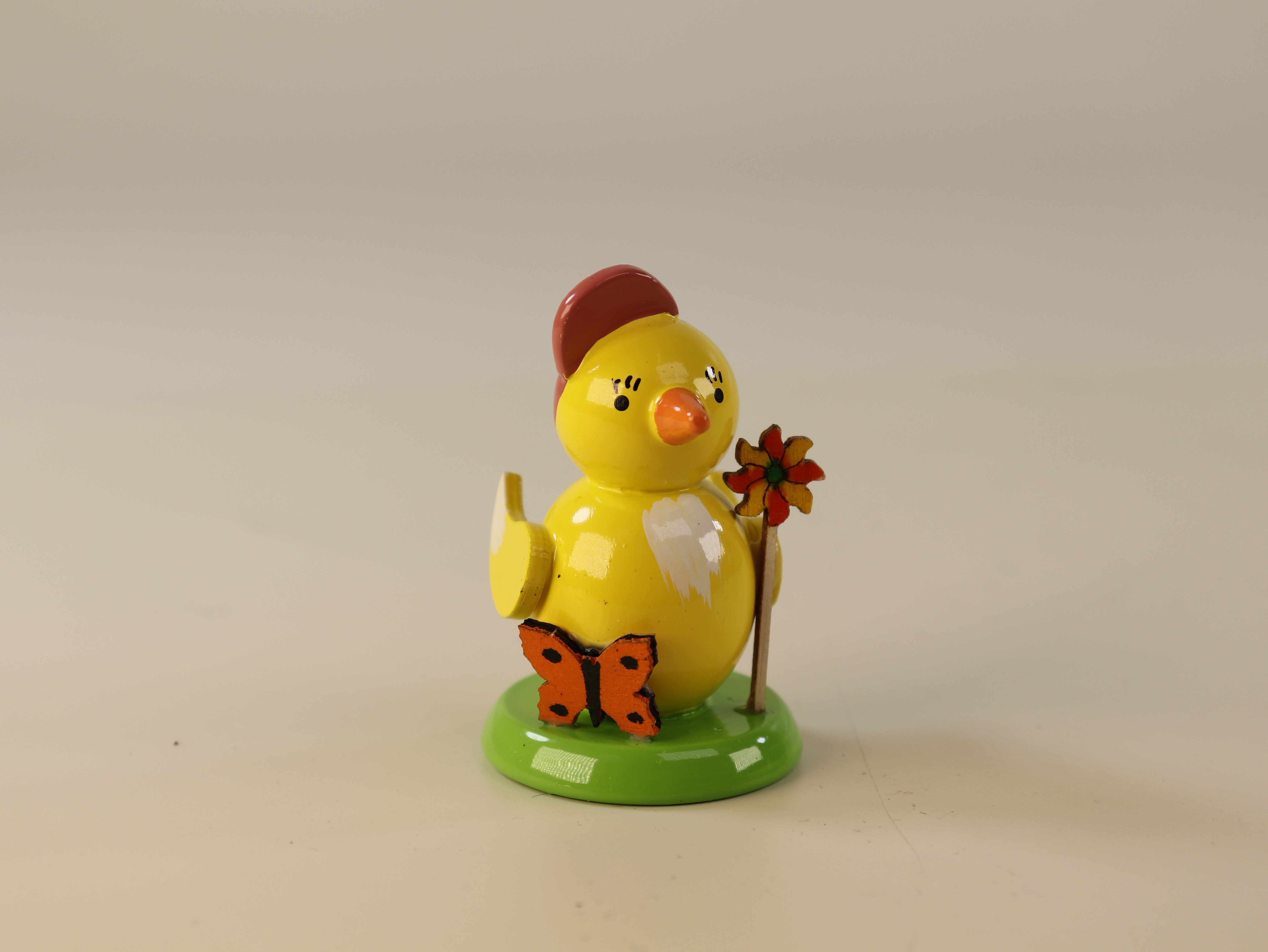 Deko Küken mit Basecap, Windrad und Schmetterling auf einem Sockel zum Hinstellen