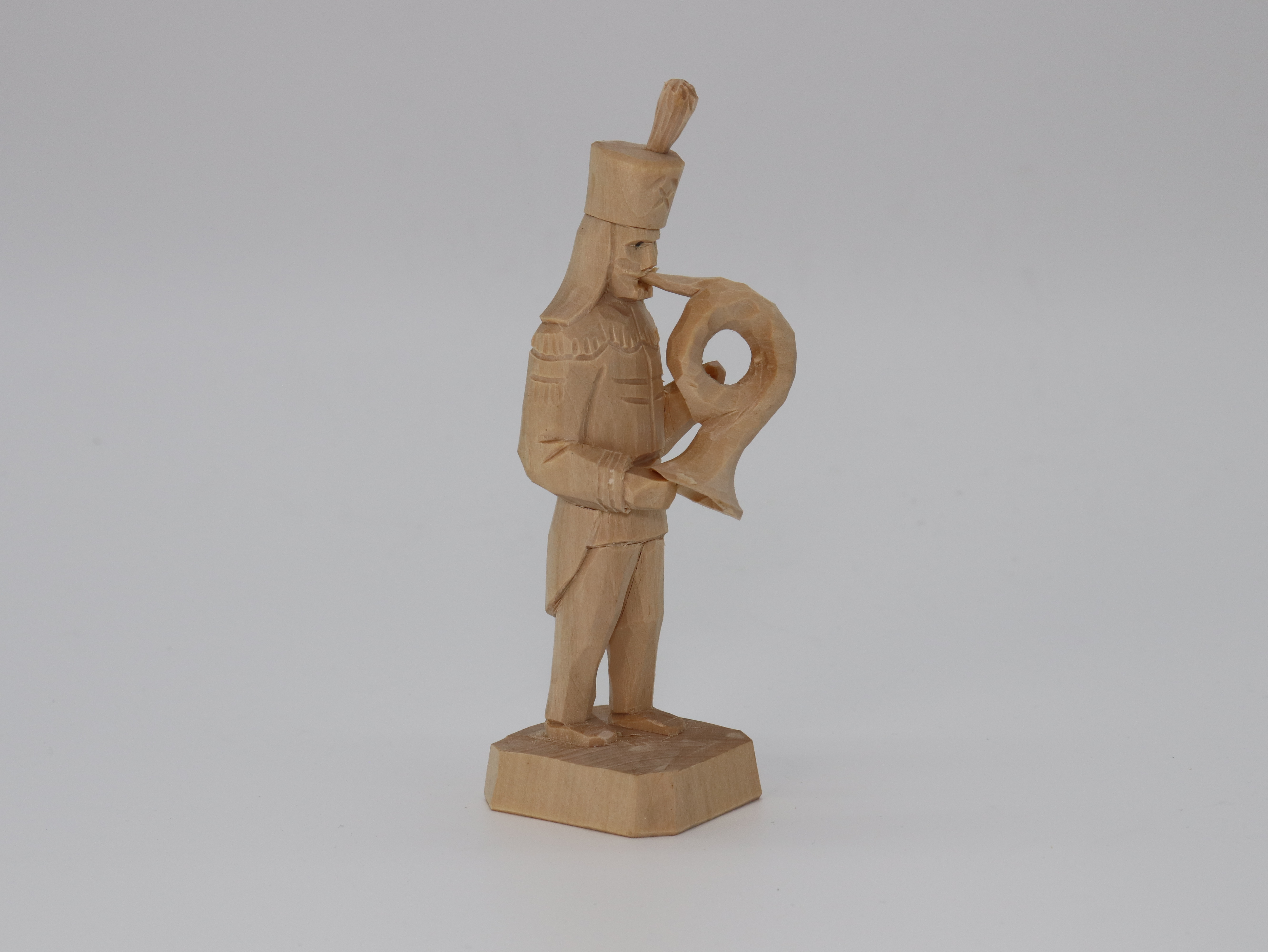 Bergmann aus Holz mit Blasinstrument in der Hand.