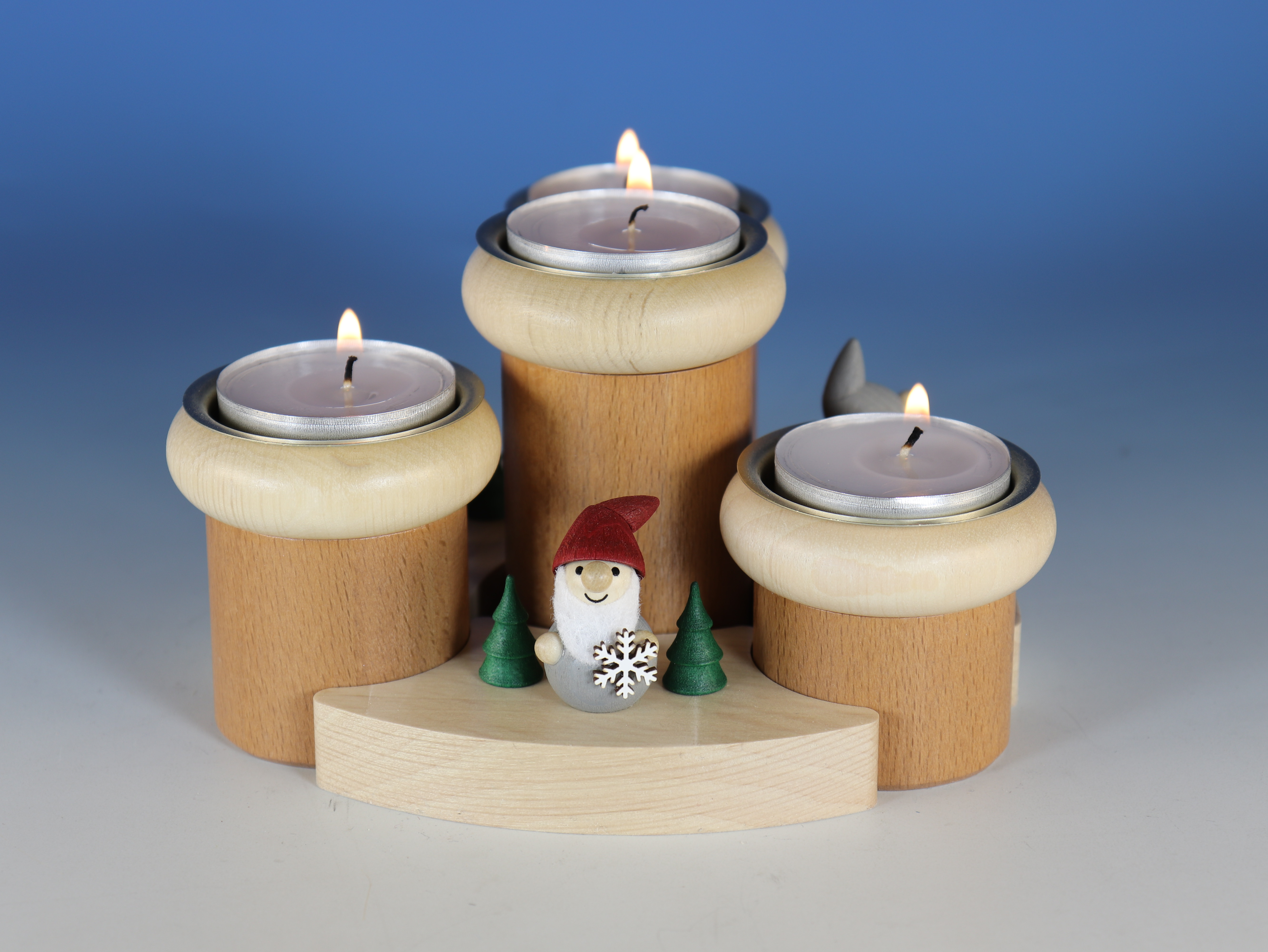 Adventsteelichthalter ausd Holz mit 3 Teelichtern und Wichteln als Figuren.
