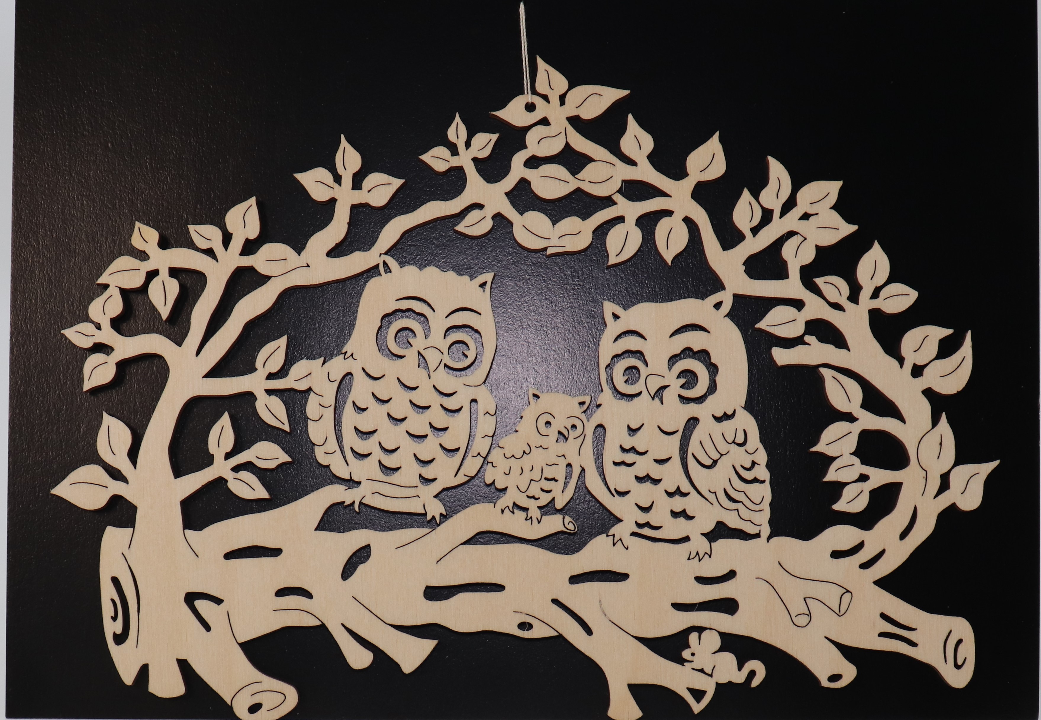 Fensterbild aus Holz mit Eulenfamilie als Motiv.