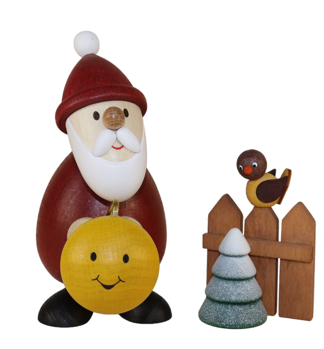 Holzfigur als Weihnachtsmann mit Lampion in der Hand und einem Zaun mit Vogel dabei.