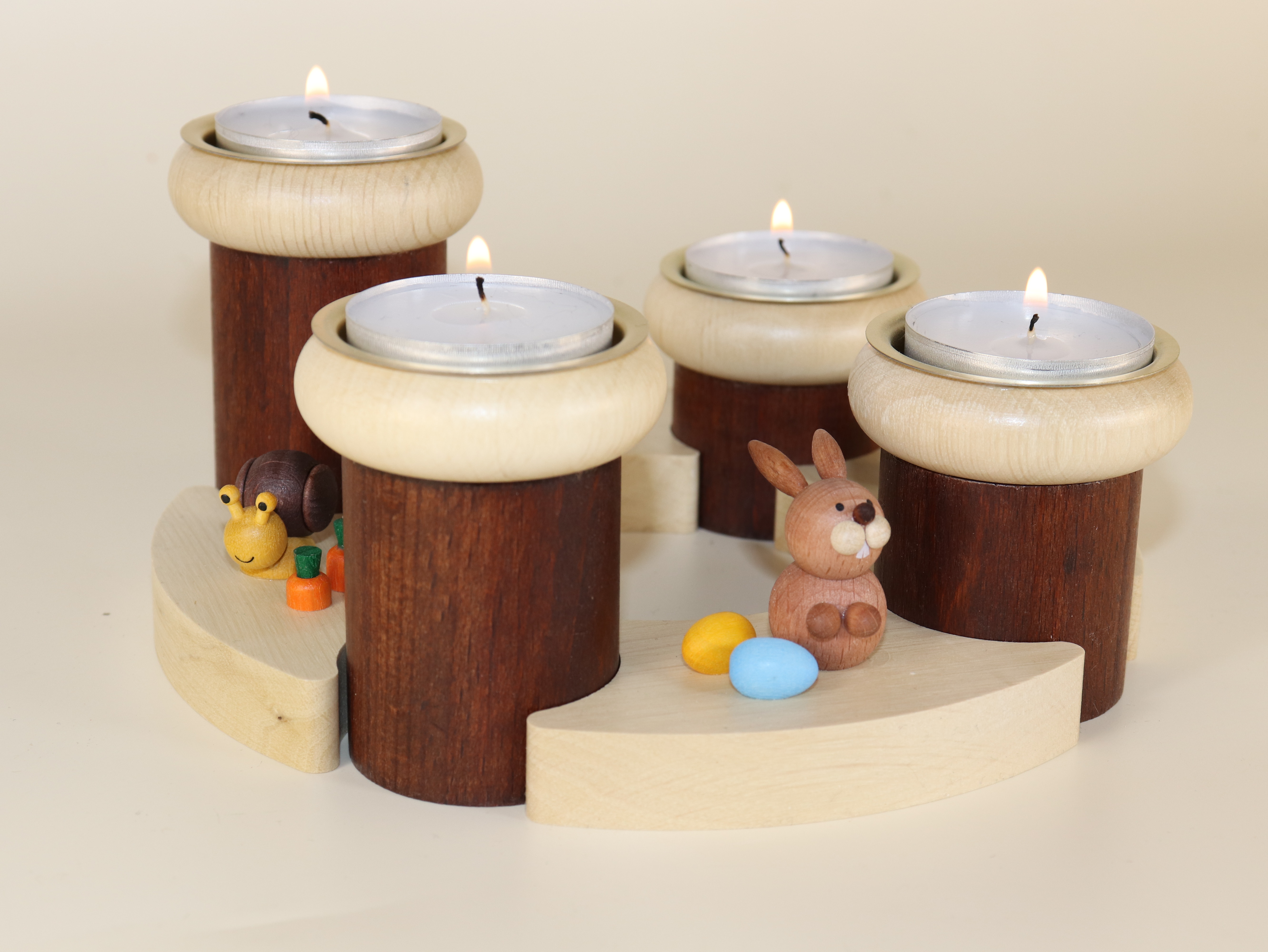 Osterkranz - Teelichthalter für 4 Teelichter mit den Figuren Hase, Schnecke, Küken und Frosch in Szene gesetzt mit angezündeten Teelichtern.